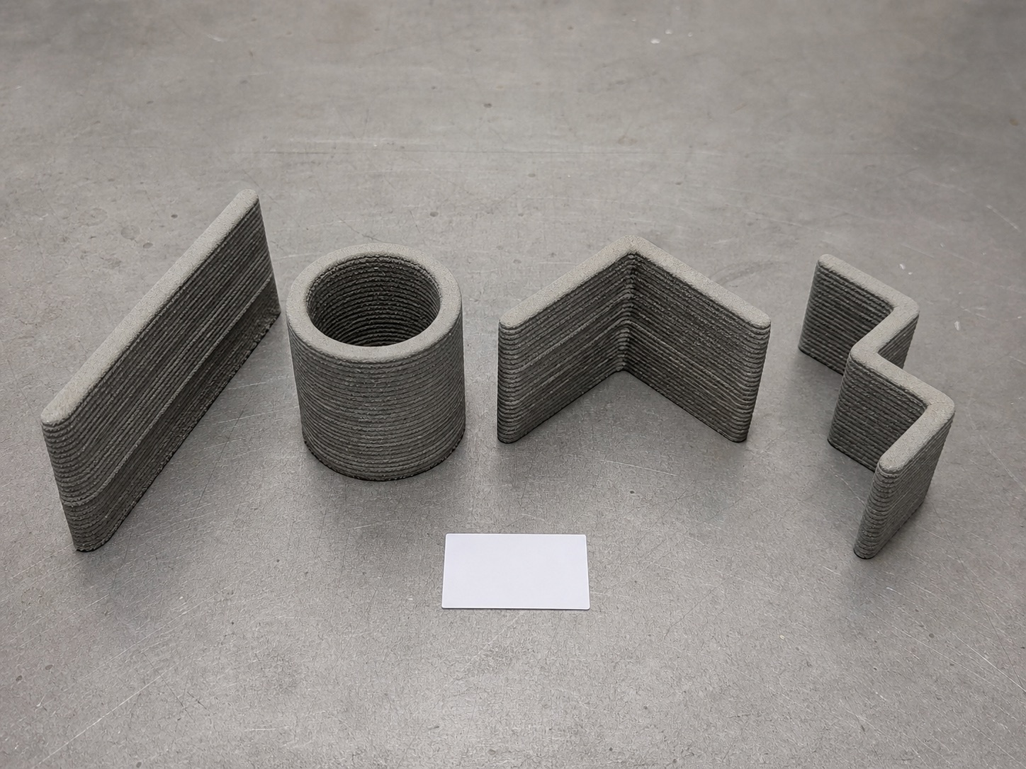 Printed test geometry beside a digital toolpath, showing the link between process design and physical output.