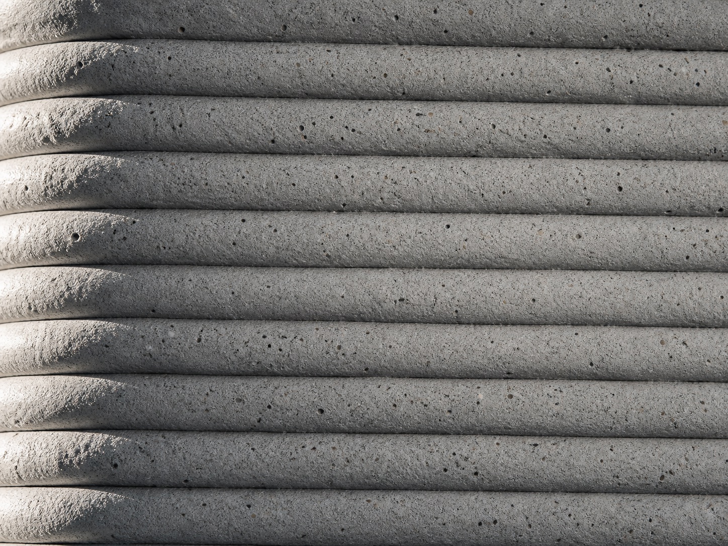 Close view of a printed mortar wall section with visible bead layers and surface texture.